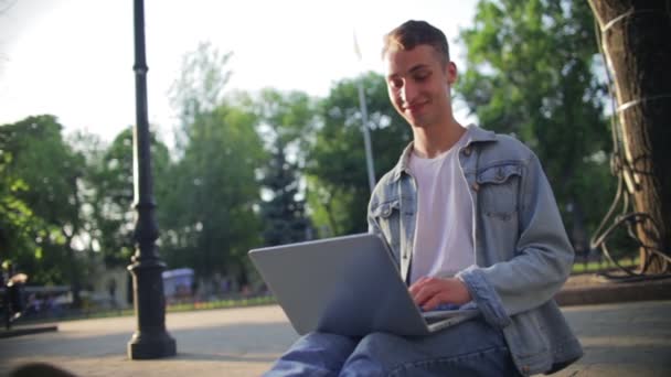 Hombre alegre en traje de mezclilla de moda abre portátil moderno — Vídeos de Stock