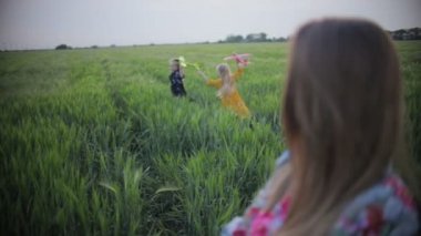 Saçları dökülmüş küçük kızlar sahada oyuncak uçaklarla oynuyorlar.