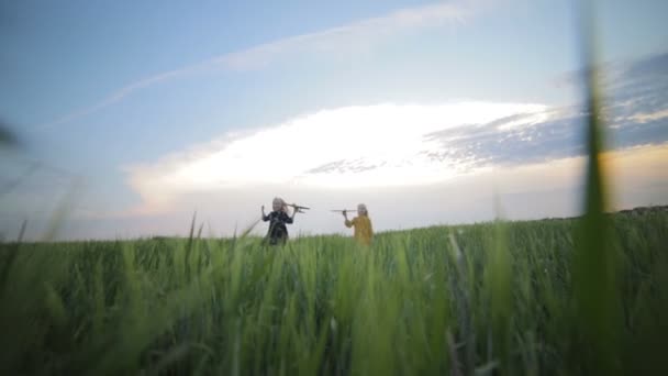 Feliz gemelo niñas lanzar juguetes aviones corriendo a lo largo de verde campo — Vídeos de Stock