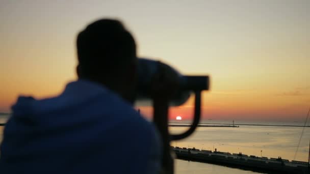 Θολή άνθρωπος κοιτάζει πορτοκαλί θαλασσογραφία αντανακλώντας το ηλιοβασίλεμα του καλοκαιριού — Αρχείο Βίντεο