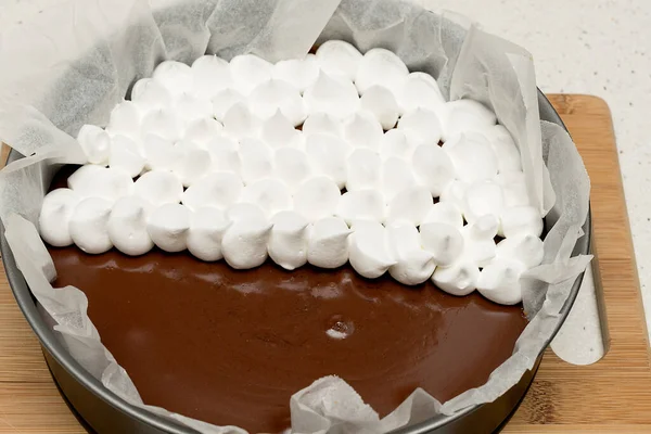 Mix of a chocolate cake with a part of meringue finishing to put in the oven