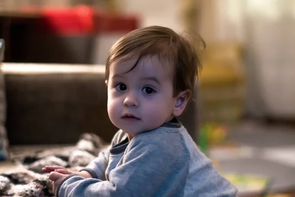 Ein Einjähriges Baby Lehnt Auf Einem Sofa Und Beobachtet Mich — Stockfoto