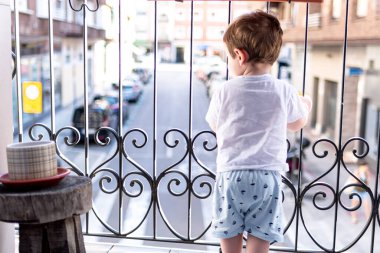 Çocuk karantinada balkondan dışarı bakıyor. İyi günler..