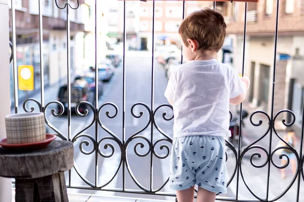 Çocuk karantinada balkondan dışarı bakıyor. İyi günler..