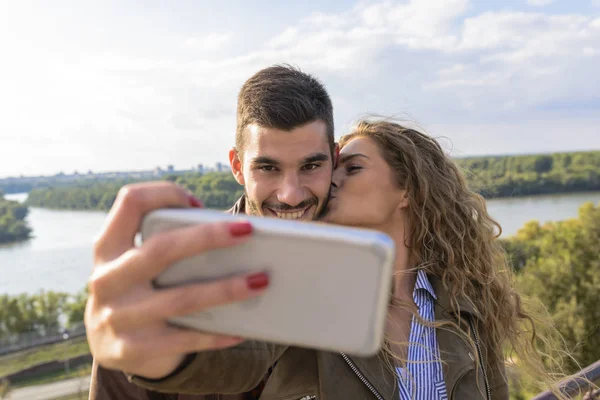 Mulher Bonita Tomando Selfie Natureza Enquanto Beija Seu Namorado Bonito — Fotografia de Stock