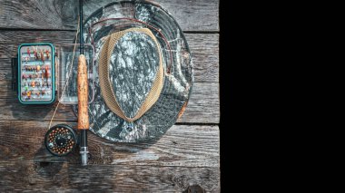 Balıkçılık malzemeleri. Bir olta, bir kutu sinek ve bir şapka..