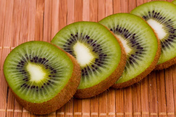 Fatias de fruto de quivi em um guardanapo de bambu. Macro tiro alimentos . — Fotografia de Stock