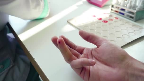 Τεστ αίματος δαχτύλων. Κοντινό πλάνο χεριών στο γάντι που παίρνουν δείγμα αίματος. Κοντινό πλάνο των εξετάσεων αίματος. Η νοσοκόμα βγάζει αίμα από το αντρικό χέρι. Ιατροδικαστική εξέταση — Αρχείο Βίντεο