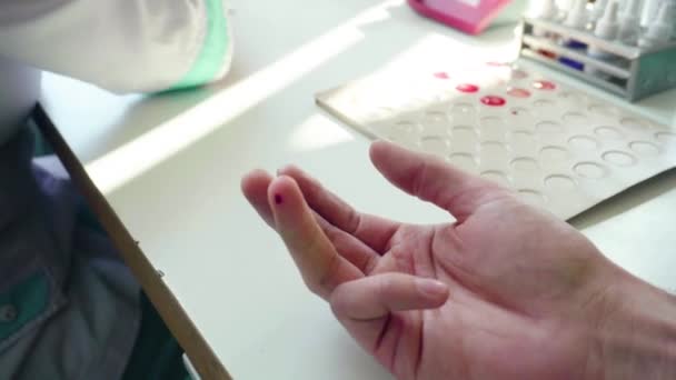 Bluttest mit dem Finger. Nahaufnahme von Händen in Handschuhen bei der Entnahme einer Blutprobe. Nahaufnahme der Blutuntersuchung. Krankenschwester entnimmt Blut aus männlicher Hand. Medizinisches Testhiv — Stockvideo