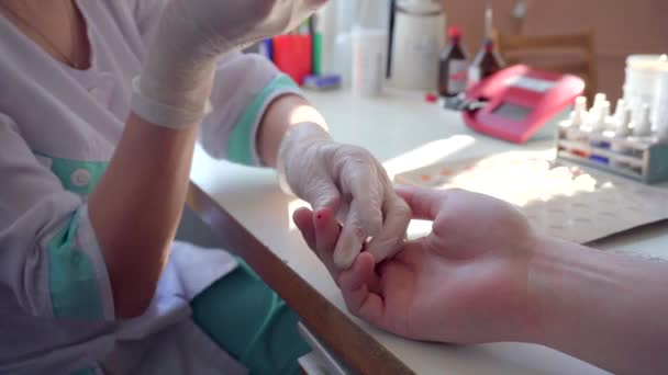 Los trabajadores médicos toman muestras de sangre en los dedos de los pacientes para pruebas de detección de salud — Vídeo de stock