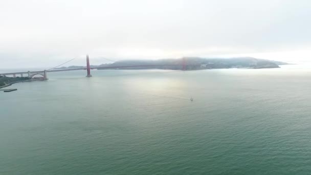 Aéreo: Voando sobre o litoral rochoso A Ponte Golden Gate no nevoeiro. São Francisco, EUA — Vídeo de Stock