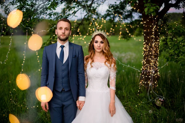 wedding couple in magical night forest decorated light garlands