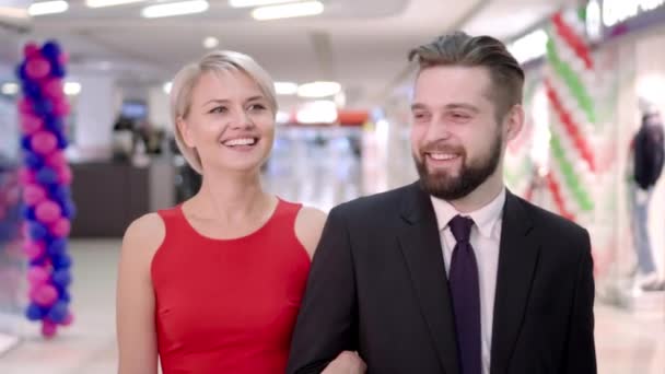 Vente, consumérisme et concept de personnes - heureux jeune couple avec des sacs à provisions marchant dans le centre commercial — Video