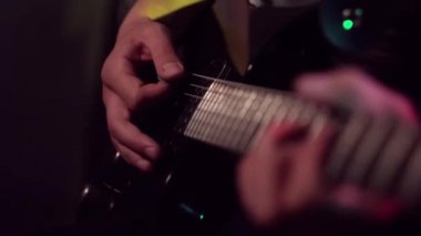 Müzisyen oynayan elektro gitar melodisi. Dizeleri ve sağ el manyetikler yakınındaki ayrıntıları.