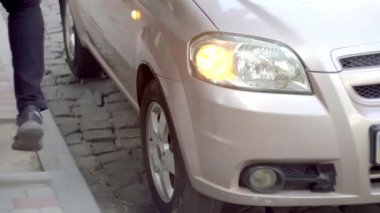 Genç adam araba tekerleğinde ayağıyla sinirli dövdü