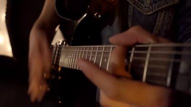 Gece sahnede elektro gitar çalan iki adamın yakın çekimi