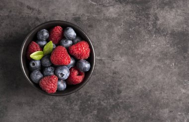 Gri arka plan üstten görünüm ahududu ve yaban mersini 