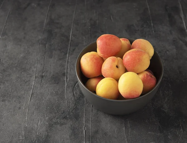 Doux délicieux abricot sur bol sombre table grise été fru frais — Photo