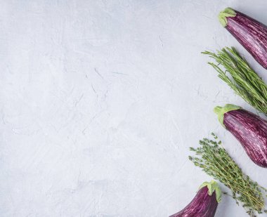 Üç sulu patlıcan graffiti ve taze kekik mavi beton bir masada yatıyor.