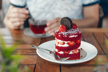Kahverengi masada çilekli kırmızı kadife kek ve çikolatalı kurabiye.