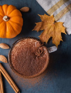 Baharatlı kahve, sinamonlu ve fındıklı latte, koyu mavi masada.