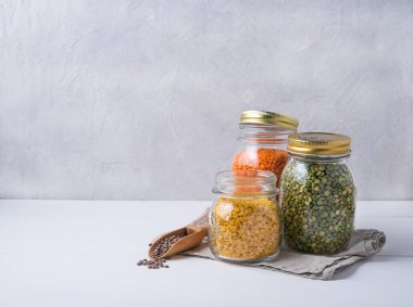 Renkli mercimek dolu bir kavanoz beyaz masada duruyor. Ön görünüm ve boşluk kopyala