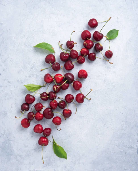 Fresh Sweet Red Cherries Green Leaves Scattered Blue Gray Table — Stock Photo, Image