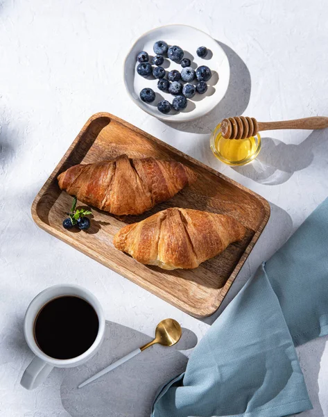 Två Croissanter Skärbräda Med Kopp Kaffe Honung Och Blåbär Vit — Stockfoto