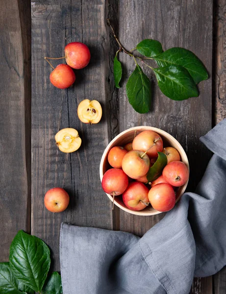 多汁的小苹果在一个碗里 用亚麻布毛巾在旧的木制背景上 乡村风格和顶级视图 — 图库照片