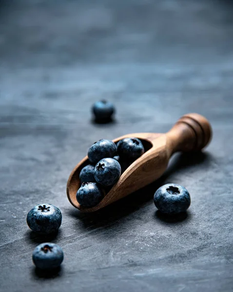濃い灰色の背景に木製のスプーンで新鮮で甘いブルーベリー トップ表示 スペースのコピー — ストック写真