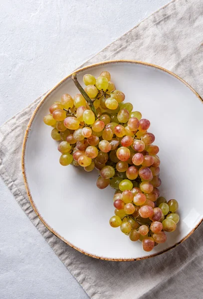 Racimo Jugosas Uvas Verdes Rosadas Plato Blanco Sobre Una Mesa —  Fotos de Stock