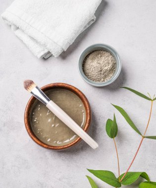 Havlu ve dallı hafif arka planda fırçalı mavi kil. Ev yapımı cilt bakımı organik kozmetik ürünleri. Üst görünüm.