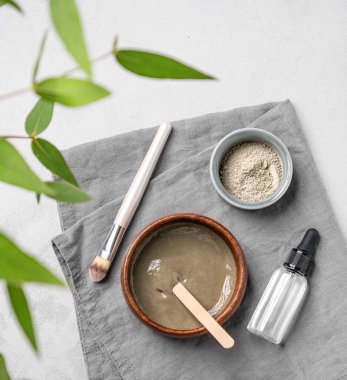 Mavi kil, serum, fırça ve dallı organik kozmetik düz bir zemin. Ev yapımı cilt bakım ürünleri hazırlama konsepti. Üst görünüm ve kopyalama alanı.