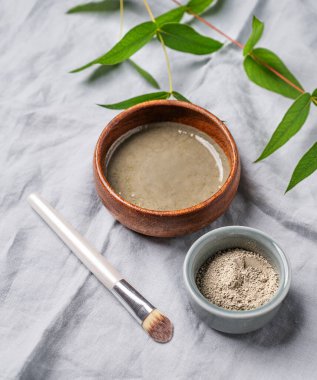 Mavi killi organik kozmetik, keten arka planda fırça ve dal. Ev yapımı cilt bakım ürünleri hazırlama kavramı. 