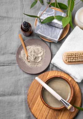 Mavi kil, sabun, fırça, serum ve havlu kaplı organik kozmetik. Ev yapımı cilt bakım ürünleri hazırlama konsepti. Üst görünüm.