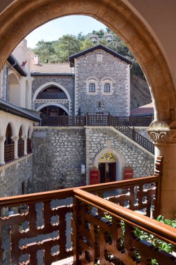 Tarihsel taş manastır avlusu. Kemerli pencereleri parlak güneş ışığıyla çekilmiş. Kemerli, miras kavramının ötesine bakıyor. Kıbrıs.