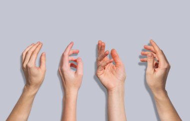 Gri bir arkaplanda dört insan eli var. İletişim ve duygu kavramı. Ön görünüm.