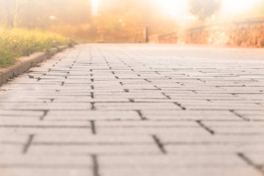 Arka planda altın ışıklı kaldırım taşlarının dokusu. Gün batımında koşmak, yürümek ve yürümek için bir yol. Metnin için yer.