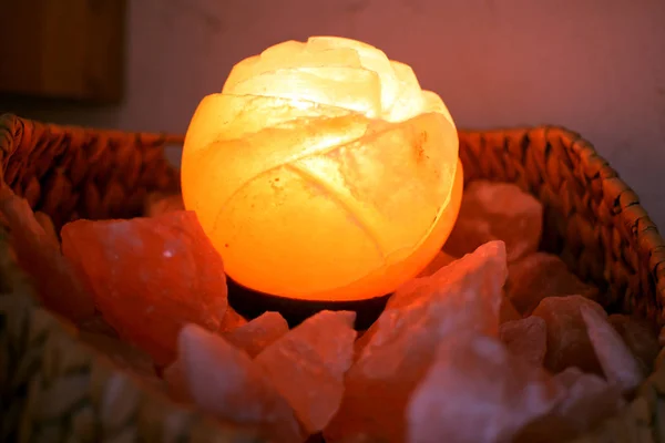 shiny crystal salt lamp in a basket full of himalaya Salt chunks closeup wallpaper background