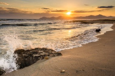 Bir kayaya su sıçrayan, gün doğumu, Mallorca plajı