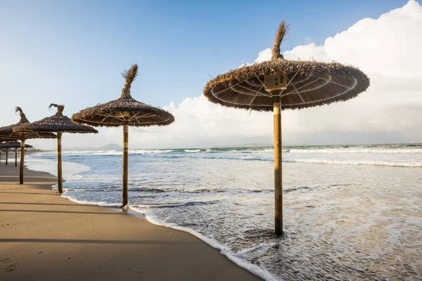 Überflutete Sonnenschirme am Strand von Mallorca Stockbild