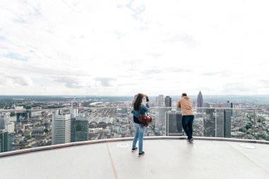 Turist çift fotoğraf çekiyor ve güneşli bir cumartesi öğleden sonra Frankfurt am Main 'in güzel gökyüzü manzarasının tadını çıkarıyor.