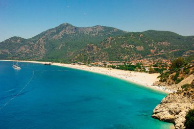 Plajda Ölüdeniz, Fethiye, Türkiye üzerinde 07 Haziran 2018 güneşli havalarda yamaç paraşütü. Blue Lagoon yakınındaki Babadağ dağ, popüler tatil ve yamaç paraşütü spot