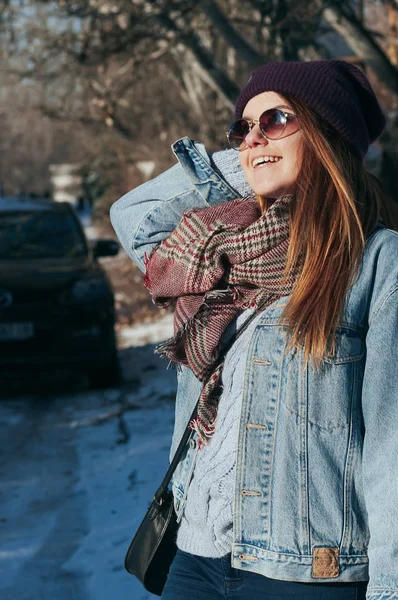 Street style Fashion portrait attractive young woman in trendy casual clothes, smiling, in sun glasses. Sunny winter day, city lifestyle