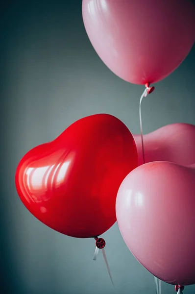 Sweet love Valentines romantic concept. Retro red pink balloons heart shape flying up against pastel blue backdrop. Film grain effect, Soft selective focus image. Motion blur
