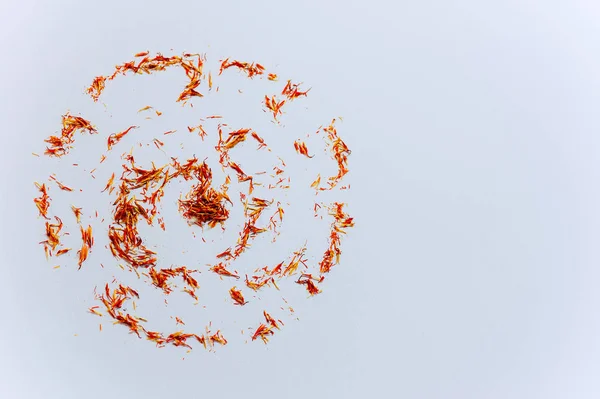 Red Saffron in shape of circle on white background. Delicate herb threads, plucked from flowers and dried. Top view of natural healthy spice. Copy space for text and design