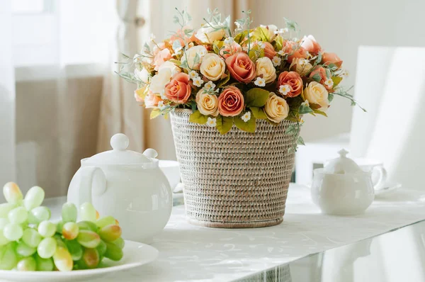 Esstisch mit Geschirr für Tee, Trauben, Blumen lizenzfreie Stockbilder