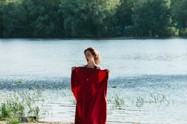 Rüzgarlı nehir kıyısında eğlenen bir kadın 