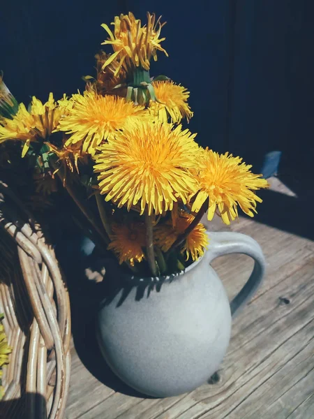 Желтые цветы в вазе на голубом деревенском фоне — стоковое фото