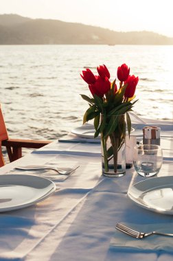 plaj restoranında çiçeklerle masa seti